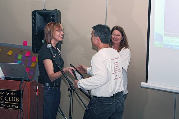 Naomi Andrew and Liz Armstrong congralate raffle winner Renato Ianella,  | DSTC Farewell Symposium, 28 July 2005  | 