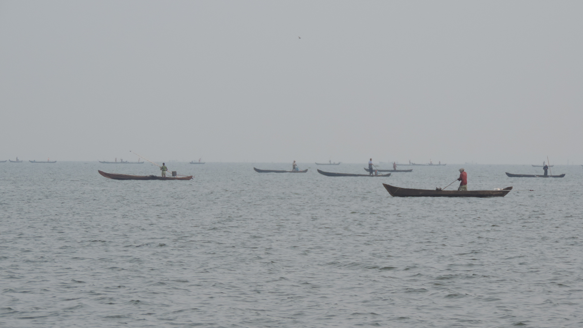 Mussel fishermen scooping up from lake floor.