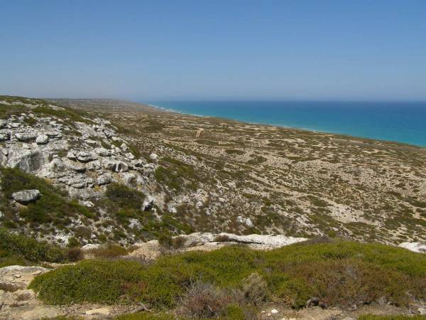 Rocky hillsides lead down to  | the Great Australian Bight,  | Nullarbor Plain,  | Eyre Highway,  | South Australia  | 