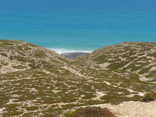 Rocky hillsides lead down to  | the Great Australian Bight,  | Nullarbor Plain,  | Eyre Highway,  | South Australia  | 