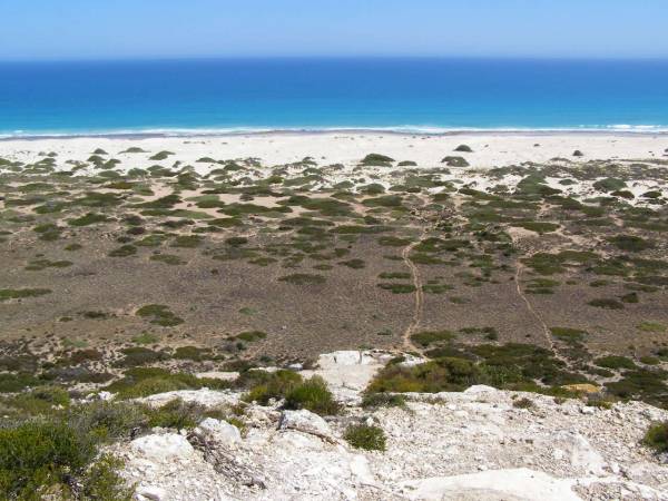 Rocky hillsides lead down to  | the Great Australian Bight,  | Nullarbor Plain,  | Eyre Highway,  | South Australia  | 
