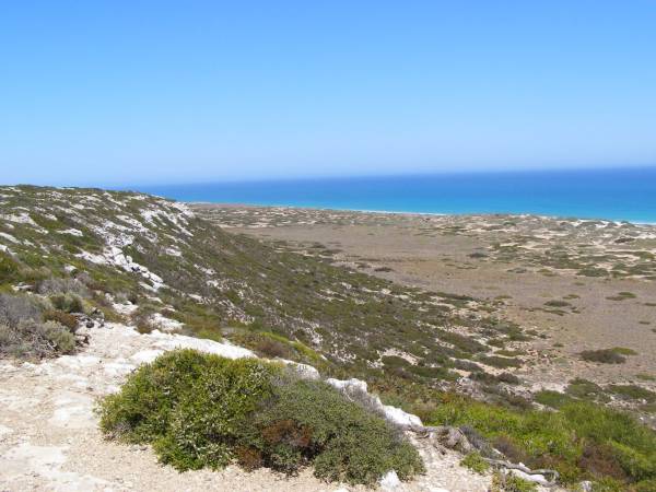 Rocky hillsides lead down to  | the Great Australian Bight,  | Nullarbor Plain,  | Eyre Highway,  | South Australia  | 